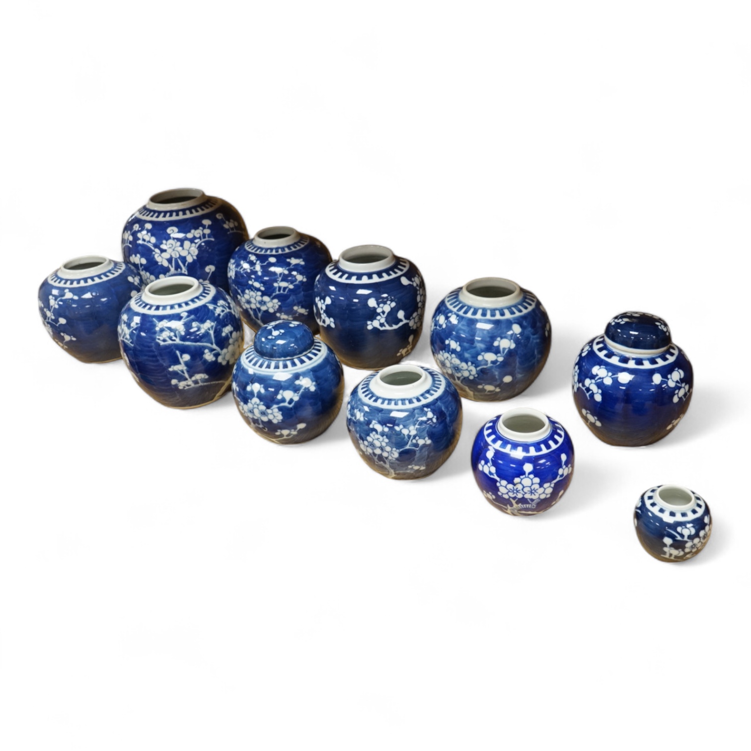 Eleven Chinese blue and white prunus jars, and two covers, late 19th/20th century, largest 16cm high